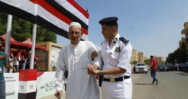 الشرطة تساعد كبار السن أمام لجان التصويت بانتخابات الشيوخ