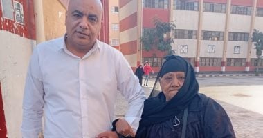 مدير مدرسة بإمبابة يساعد كبار السن للإدلاء بأصواتهم فى انتخابات النواب