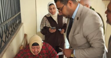 قاضى يساعد مسنة للإدلاء بصوتها فى جولة الإعادة لانتخابات النواب بالشرقية