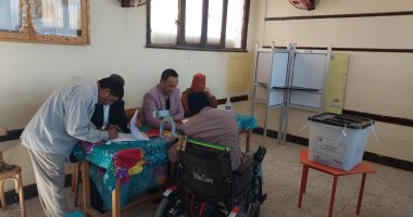 رئيس لجنة بجولة إعادة انتخابات النواب بمركز بلاط يساعد ناخب على كرسى متحرك للإدلاء بصوته