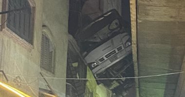 الأمن يدفع بمعدات لإنزال أتوبيس تعلق بين منزل دائرى أحمد عرابى وعقار.. صور