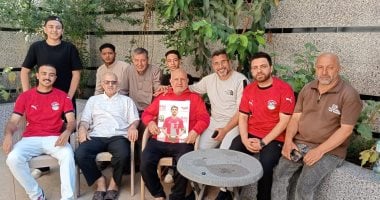 والد محمود صابر لاعب المنتخب ممسك بصورته ومع ابناء عمومته