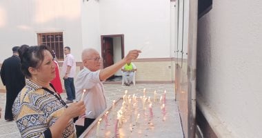 شموع بجوار صورة السيدة العذراء