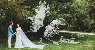 بالصور.. فكرة مجنونة لفنان يصنع تمثالا له وعروسه فى يوم الزفاف