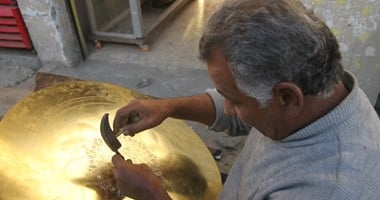 عم "مجدى" نقّاش نحاس على باب مقبرة والمعرض "كشك سجاير"