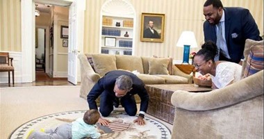 صورة طريفة للرئيس أوباما يداعب طفلا فى البيت الأبيض