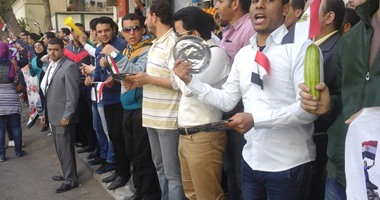 حملة الماجستير يستخدمون الأطباق أثناء تظاهرهم أمام مجلس الوزراء