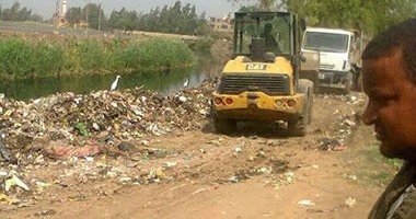 أهالى كفر عمر بالشرقية يشكون من إلقاء سيارات مجلس المدينة القمامة بمصرف قريتهم