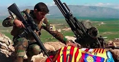 مقاتل بشمركى يحمل قميص ميسي وعلم برشلونة احتفالاً بالانتصار على "داعش"