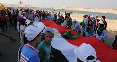بالصور.. وفد الشباب يرفعون لافتة "ضد الإرهاب" على ضفة قناة السويس الجديدة