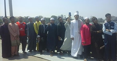 طلاب ماليزيون يلتقطون صورًا تذكارية على كوبرى قصر النيل احتفالا بالعيد
