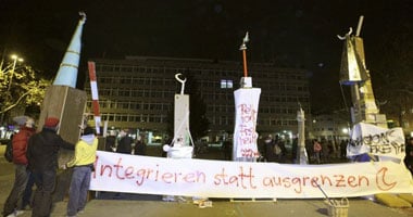 بالصور.. احتجاجات مسلمى سويسرا بارتداء المآذن الورقية