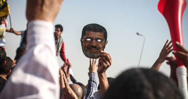 بالصور.. قناع لوجه "مرسى" يتصدر قائمة "التايم" لأفضل 10 صور بالعالم