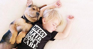 بالصور.. علاقة صداقة قوية تجمع طفل وكلبه تظهر أثناء نومهما