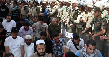 المتظاهرون أمام "الدفاع" يؤدون صلاة الظهر فى جماعة
