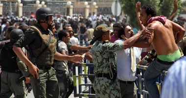 بالصور.. معركة بالحجارة بين أهالى الشهداء والأمن أثناء محاكمة "العادلى"