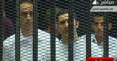 جمال وعلاء يمسكان بالمصحف داخل القفص ويحاولان منع تصوير مبارك 