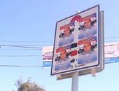 مرشح بأسيوط يطمس إشارات مرور الطريق السريع بملصقات دعايته الانتخابية