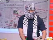 جابر القرموطى يرتدى العقال الفلسطينى ويحمل حجارة للتضامن مع قضية القدس