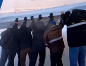 بالفيديو.. ركاب طائرة روسية يدفعونها بأيديهم بسبب تجمدها