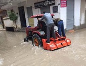 "جرار" ينقل المواطنين بعد غرق الشوارع بالمياه بمنطقة أبيس فى الإسكندرية