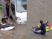 بالفيديو.. مواطن إسكندرانى يتحدى الأمطار ويعبر الشارع فى عوامة