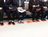 بالصور.. كوريا تنشر ملصقات برتقالية لوضع الأقدام بعربات المترو لمنع التحرش