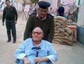 بالصور.. الأمن يساعد "مسن" على الإدلاء بصوته بالانتخابات فى الشرقية