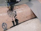 بالفيديو... باحثون فرنسيون يبتكرون روبوت يرسم "تاتو" على جلد الإنسان
