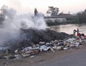 بالصور.. موظفو الوحدة المحلية فى نبروة يحرقون القمامة على ضفاف النيل 