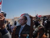 المصريون المحررون فى ليبيا يرفعون صور السيسى عقب وصولهم معبر السلوم