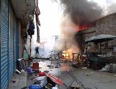 بالصور.. إخماد حريق بمبنى وسط سوق الخضار فى نجع حمادى