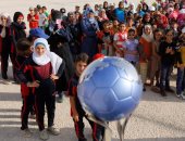   أطفال سوريا اللاجئين يلتقطون صورًا تذكارية مع كأس العالم للسيدات
