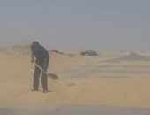 بالصور.. "مسعف" يزيل الكثبان الرملية من طريق بالوادى الجديد منعا للحوادث