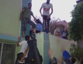 بالصور.. أولياء أمور يقفزون من أعلى سور مدرسة بفاقوس لحجز المقاعد