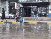 بالصور.. لقطة طريفة لمواطن يصطاد بصنارة من مياه الأمطار بالغردقة