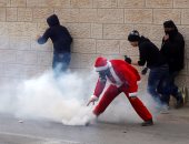 بالصور.. فلسطينيون فى زى بابا نويل يشتبكون مع قوات الاحتلال الإسرائيلى