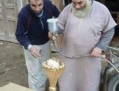 بالصور.. أهالى دمياط يصنعون نسخة كأس أمم إفريقيا من الخشب
