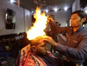 بالصور.. النار أغرب وسيلة لتصفيف الشعر وفرده فى قطاع غزة 