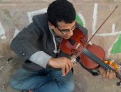 بالفيديو والصور.. شاب يتحدى إعاقته بعزف الكمان على كورنيش الإسكندرية