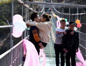 بالصور.. "قُبلات" عيد الحب فى مسابقة صينية على جسر زجاجى
