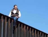سياسى مكسيكى يتسلق الجدار الحدودى مع أمريكا ليسخر من خطة ترامب