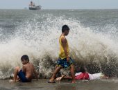 بالصور.. بعد "إعصار نيسات".. شواطئ مانيلا تستقطب الأطفال