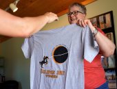 بالصور.. أمريكيون يستعدون لكسوف الشمس بشراء التى شيرتات والنظارات والقبعات