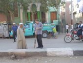 بالصور .. رئيس مدينة منفلوط يكنس الشوارع..ويشرح طريقة الكنس الصحيح