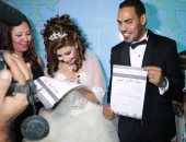  بالصور.. عروسان بأسيوط يحتفلان بالتوقيع على استمارة "علشان تبنيها"