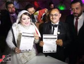 بالصور.. عروسان يوقعان استمارة "علشان تبنيها" فى حفل زفافهما