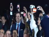 ضيوف منتدى شباب العالم يرفعون أعلام بلادهم على الهواتف المحمولة مع علم مصر