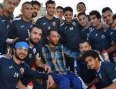 لاعبو الزمالك يلتقطون صورا مع مشجع من ذوى الاحتياجات الخاصة