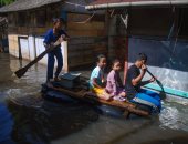 صور.. مواطنو إندونيسيا يستخدمون المراكب فى الشوارع بسبب الفيضانات